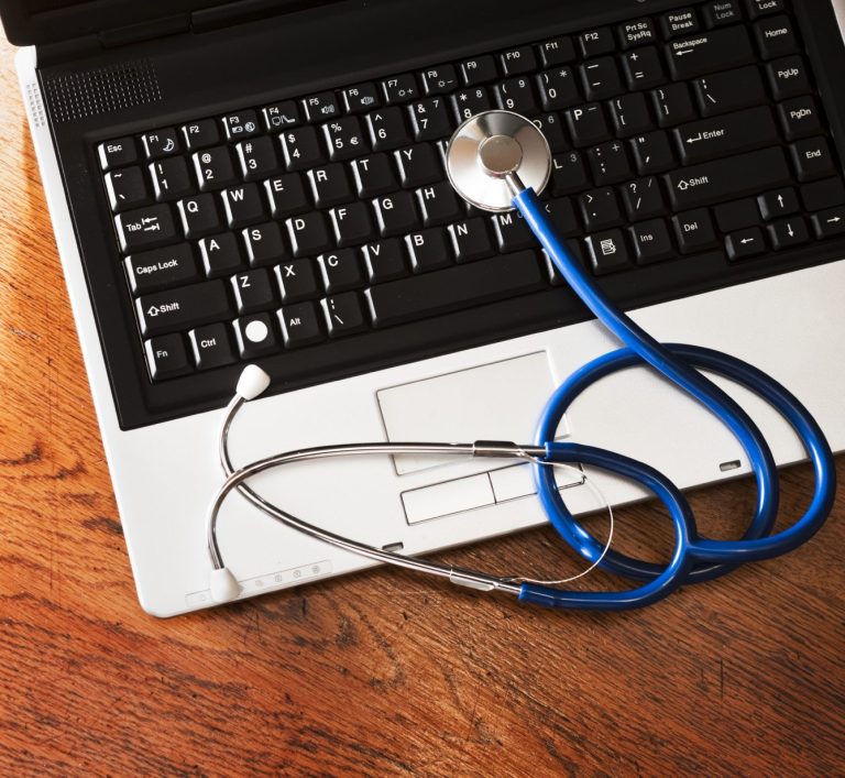 A stethoscope listening to a laptop keyboard